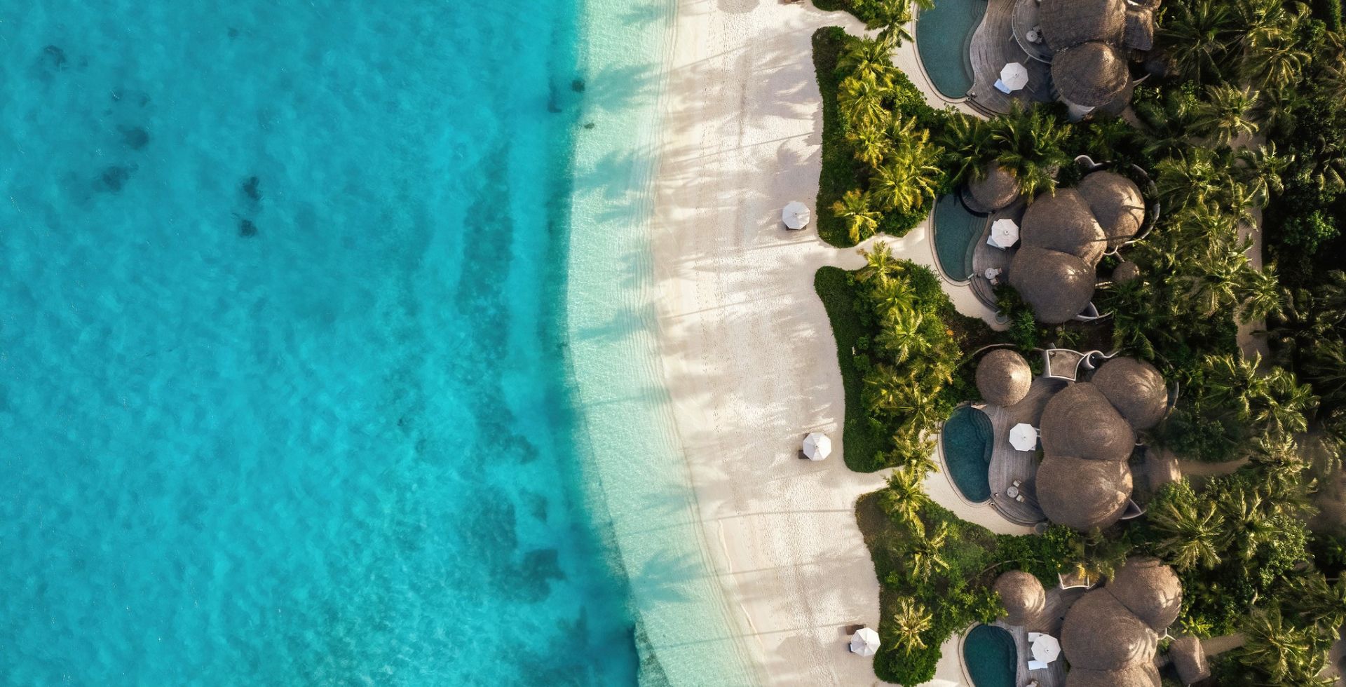 Strandvilla zwischen Palmen und türkisfarbener Lagune