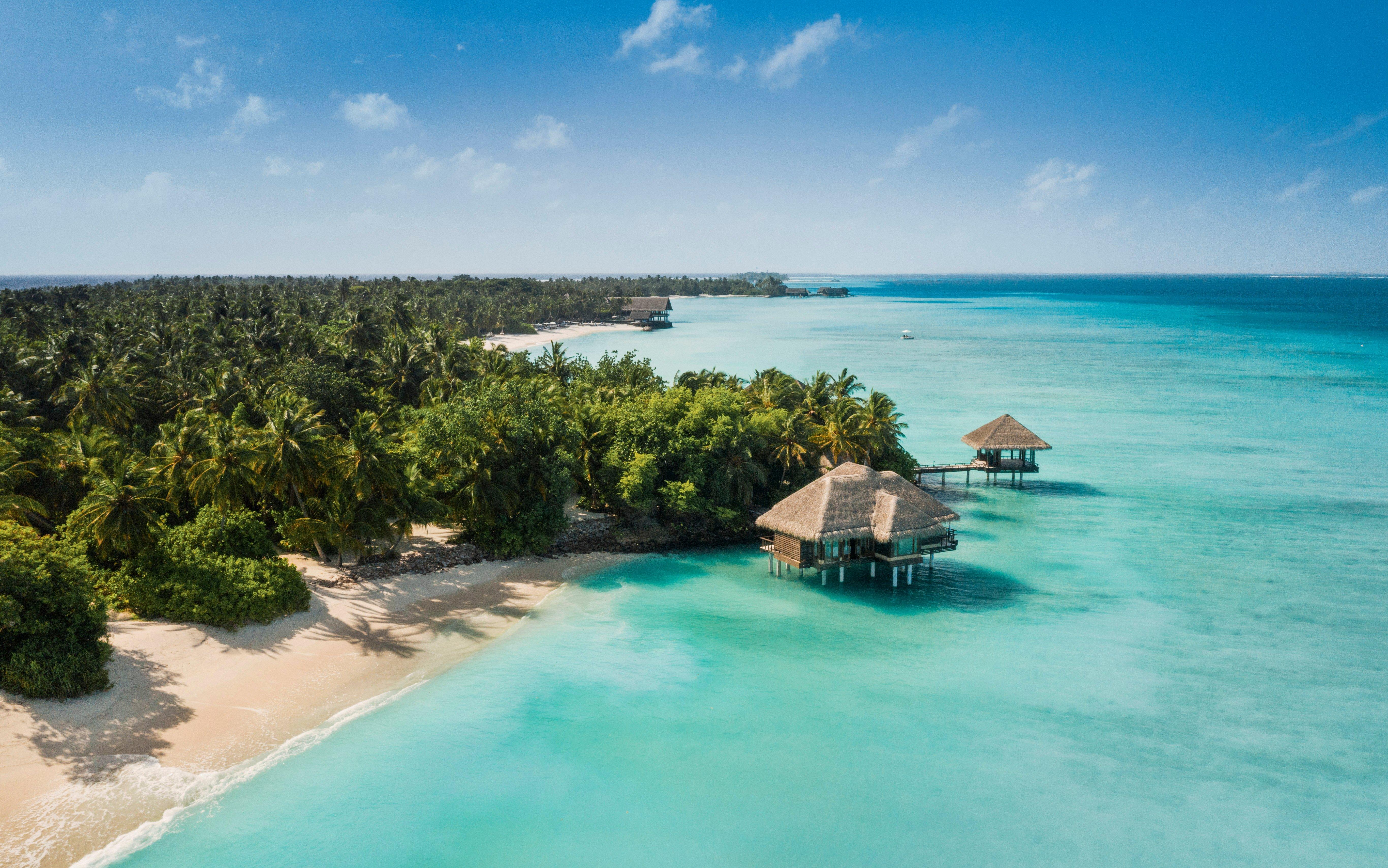 Luftaufnahme von One&Only Reethi Rah mit Inselgrün, weißen Stränden, türkisfarbener Lagune und mehreren Wasservillen im Nord-Malé-Atoll